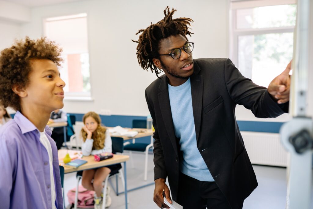 Een leerkracht legt iets uit aan een leerling